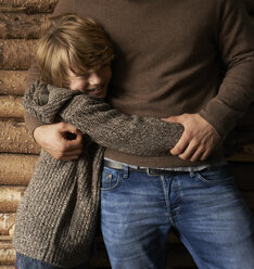 Lächelnder Sohn umarmt Vater - CAIF00845