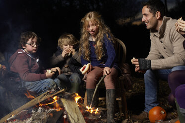 Familie beim abendlichen Essen am Lagerfeuer - CAIF00847