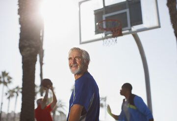 Ältere Männer spielen Basketball auf dem Platz - CAIF00859