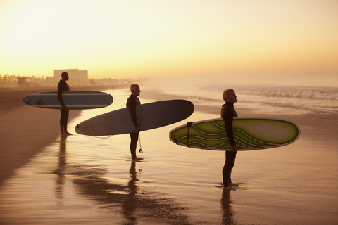 Surfer halten Bretter am Strand, lizenzfreies Stockfoto