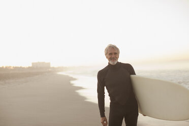 Älterer Surfer mit Brett am Strand - CAIF00875
