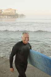 Älterer Surfer mit Brett am Strand - CAIF00876