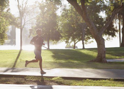 Man jogging in park stock photo