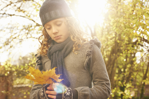 Mädchen trägt Herbstblatt im Freien, lizenzfreies Stockfoto