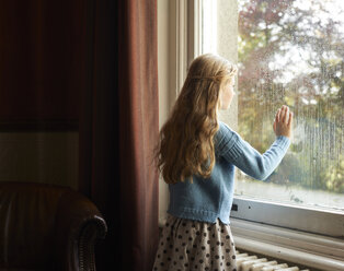 Girl looking out window - CAIF00929