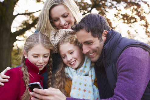 Familie benutzt Mobiltelefon im Freien - CAIF00934