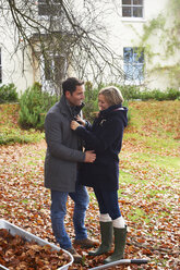 Lächelndes Paar im Herbstlaub stehend - CAIF00945