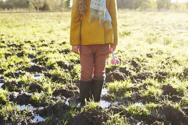 Girl standing in muddy field - CAIF00965