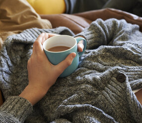 Close up of boy holding cup of tea - CAIF00966