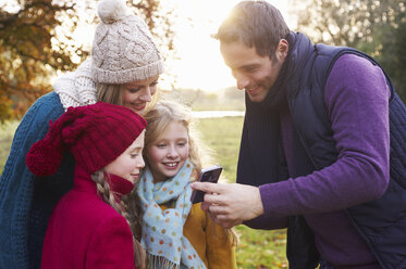 Familie telefoniert gemeinsam im Freien - CAIF00967