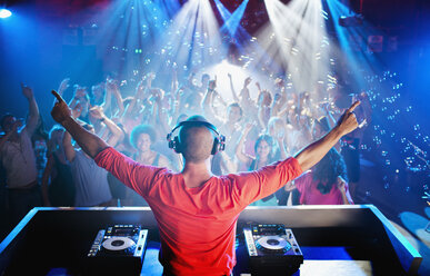 DJ with arms outstretched overlooking dance floor - CAIF01046