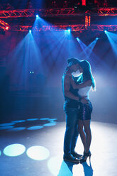 Paar tanzt und umarmt sich auf leerer Tanzfläche in einem Nachtclub - CAIF01064