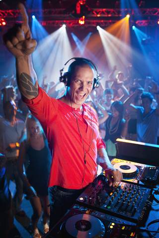 Porträt eines begeisterten DJs am Plattenteller in einem Nachtclub, lizenzfreies Stockfoto