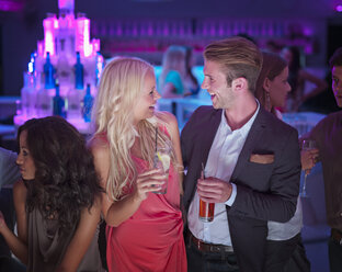 Lächelndes Paar trinkt Cocktails in einem Nachtclub - CAIF01099