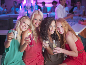 Porträt von lächelnden Frauen mit Cocktails in einem Nachtclub - CAIF01109
