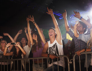 Begeistertes Publikum mit erhobenen Armen hinter dem Geländer beim Konzert - CAIF01121