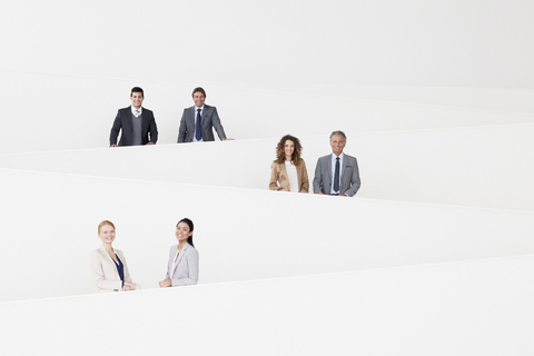 Porträt von lächelnden Geschäftsleuten auf einer modernen Treppe, lizenzfreies Stockfoto