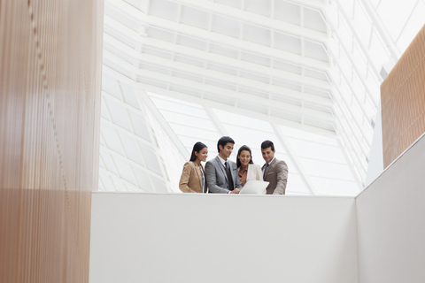 Geschäftsleute bei der Durchsicht von Papierkram in einem modernen Gebäude, lizenzfreies Stockfoto