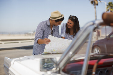Ehepaar liest Straßenkarte auf Cabrio - CAIF01161