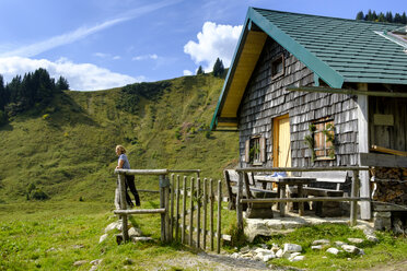 Germany, Bavaria, woman at rustic house in the mountains near Lenggries - LBF01807