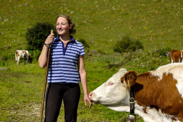 Deutschland, Bayern, lächelnde junge Frau mit Kuh in den Bergen - LBF01810