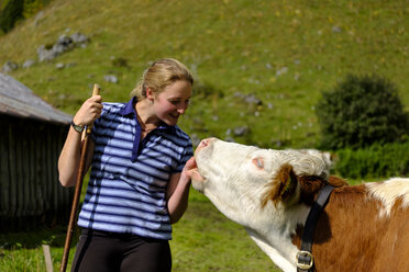 Deutschland, Bayern, lächelnde junge Frau mit Kuh in den Bergen - LBF01811