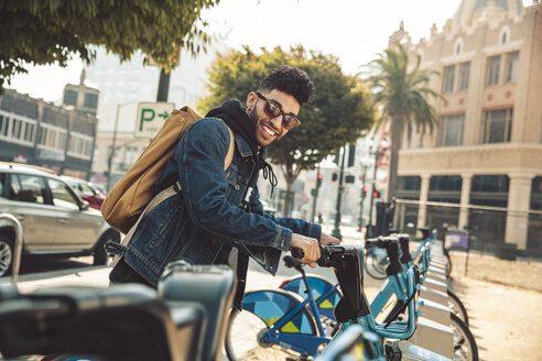 Stylish young man on the street with rental bike - SUF00472