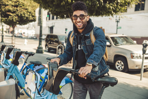 Stylish young man on the street with rental bike - SUF00473