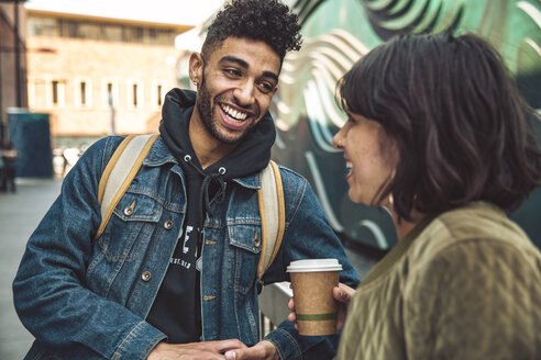 Happy young man and woman with coffee talking in the city - SUF00475