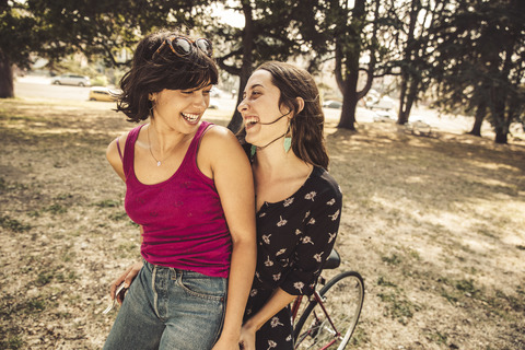 Zwei glückliche junge Frauen auf dem Fahrrad, lizenzfreies Stockfoto