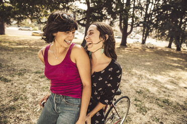 Two happy young women on bicycle - SUF00524