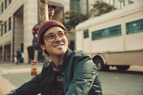 Portrait of stylish young man sitting on sidewalk - SUF00526