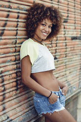 Portrait of smiling woman with afro hairstyle outdoors - JSMF00001