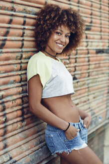 Porträt einer lächelnden Frau mit Afrofrisur im Freien - JSMF00001