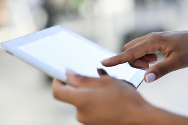 Close-up of woman's hands using tablet outdoors - JSMF00012