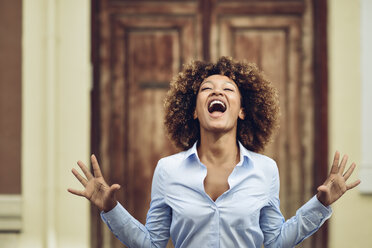 Portrait of woman with afro hairstyle screaming outdoors - JSMF00028