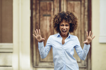 Portrait of woman with afro hairstyle screaming outdoors - JSMF00033