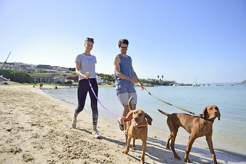 Young couple walking on the beach with dog - ECPF00180