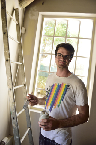 Portrait of smiling young man renovating his home stock photo