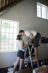 Young couple kissing during renovating their home - ECPF00193
