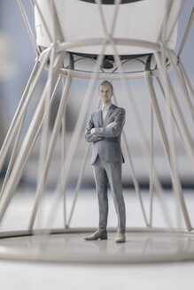 Miniature businessman figurine standing inside structure under VR glasses - FLAF00141