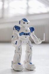 Miniature robot figurine holding laptop - FLAF00144