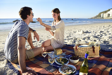 Glückliches Paar beim Picknick am Strand - ECPF00208