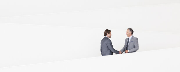 Geschäftsleute schütteln sich die Hände auf einer modernen Treppe - CAIF01236