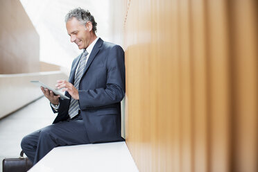 Businessman using digital tablet in office - CAIF01299