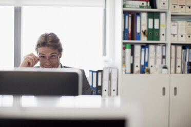 Geschäftsmann liest E-Mails am Computer im Büro - CAIF01318