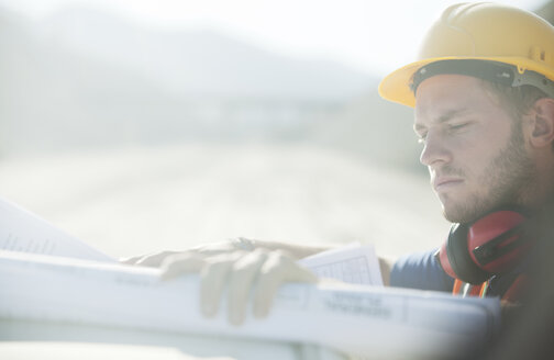 Worker reading blueprints on site - CAIF01327