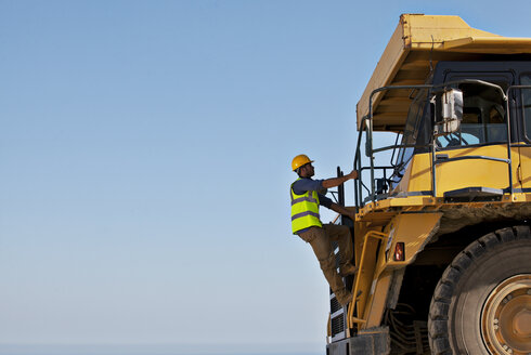 Arbeiter klettert auf der Baustelle auf Maschinen - CAIF01341