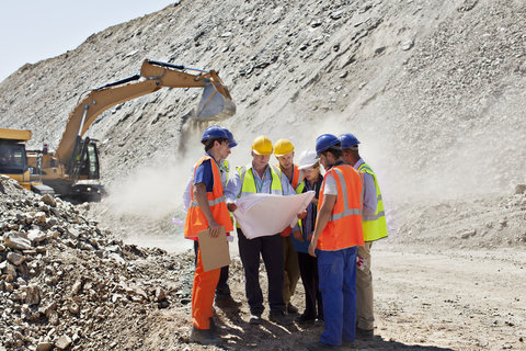 Business people and workers talking in quarry stock photo