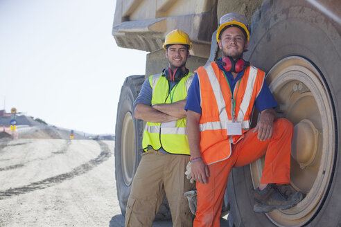 Workers leaning on machinery on site - CAIF01397